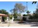 The private backyard features a charming fountain, mature landscaping, and a covered patio at 1417 W Lake Mirage Ct, Gilbert, AZ 85233