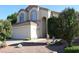 Inviting two-story stucco home featuring a two car garage, red rock landscaping and manicured bushes at 1417 W Lake Mirage Ct, Gilbert, AZ 85233