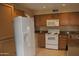 Kitchen featuring granite counters, a white fridge, stove, and plenty of cabinets at 1417 W Lake Mirage Ct, Gilbert, AZ 85233