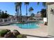 Community pool with clear blue water, surrounded by palm trees and well-maintained landscaping at 1417 W Lake Mirage Ct, Gilbert, AZ 85233
