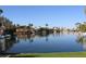 Beautiful waterfront view of homes along the lake lined with palm trees on a sunny day at 1417 W Lake Mirage Ct, Gilbert, AZ 85233