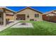 Manicured backyard with artificial turf, pavers, fire pit, and covered patio furniture at 16573 W Alameda Rd, Surprise, AZ 85387