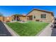 Manicured backyard with artificial turf, pavers, a fire pit, and outdoor furniture at 16573 W Alameda Rd, Surprise, AZ 85387