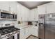 Bright kitchen with white cabinets, stainless steel appliances, and granite countertops at 16573 W Alameda Rd, Surprise, AZ 85387