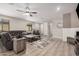 Open living space featuring wood tile floors, neutral paint, modern decor, and a large sectional at 16573 W Alameda Rd, Surprise, AZ 85387