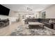 Open-concept living room featuring wood tile floors, a ceiling fan, and a leather couch at 16573 W Alameda Rd, Surprise, AZ 85387