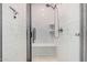 Modern shower featuring white subway tile, a glass door, and a built-in bench at 16573 W Alameda Rd, Surprise, AZ 85387