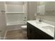 Bathroom features a tub and shower combination with double sinks, white subway tiles, and dark cabinets at 17633 W Pierson St, Goodyear, AZ 85395