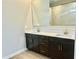 Bathroom boasts double sinks, sleek dark cabinets, modern fixtures, a large mirror, and a glass-enclosed shower at 17633 W Pierson St, Goodyear, AZ 85395