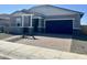 Charming single-story home boasts a paved driveway, dark garage door, and stylish stone accents enhancing curb appeal at 17633 W Pierson St, Goodyear, AZ 85395