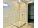 Shower features a glass enclosure, bench, beige tile, and modern fixtures for a luxurious and contemporary spa feel at 17633 W Pierson St, Goodyear, AZ 85395
