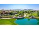 Aerial view displays the lush landscaping, lake, and golf course surrounding the community clubhouse at 187 E Santa Lucia Ln, Queen Creek, AZ 85140