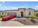 Charming single-story home with a well-manicured front yard and a striking red sports car in the driveway at 187 E Santa Lucia Ln, Queen Creek, AZ 85140