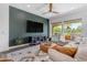 Modern living room with a large sectional sofa, stylish rug, and dark accent wall, creating a comfortable gathering space at 187 E Santa Lucia Ln, Queen Creek, AZ 85140