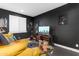 Stylish living room with a large flat-screen TV, dark walls, a comfortable yellow couch, and movie decor at 187 E Santa Lucia Ln, Queen Creek, AZ 85140