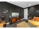 Open-concept living room featuring dark walls, a large flat-screen TV, stylish decor, and hardwood floors at 187 E Santa Lucia Ln, Queen Creek, AZ 85140