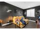 Cozy living room featuring dark gray walls, hardwood floors, and a comfortable yellow couch, perfect for movie nights at 187 E Santa Lucia Ln, Queen Creek, AZ 85140