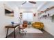 Stylish home office with a mid-century desk, mustard sofa, accent wall art, and floating shelves at 187 E Santa Lucia Ln, Queen Creek, AZ 85140