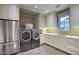 Functional laundry room with stainless steel appliances, custom cabinets, and ample counter space at 18916 N 98Th St # 3709, Scottsdale, AZ 85255