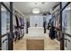 Large walk-in closet with custom shelving, hanging rods, and a central island for storage at 18916 N 98Th St # 3709, Scottsdale, AZ 85255