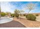 Backyard area featuring desert landscaping, mature trees, and lounge seating at 21026 N Circle Cliffs Dr, Surprise, AZ 85387