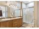 Bathroom with double sinks, granite countertop, wood cabinets, and glass shower enclosure at 21026 N Circle Cliffs Dr, Surprise, AZ 85387