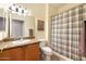 Cozy bathroom with granite countertop vanity, and shower with a plaid curtain at 21026 N Circle Cliffs Dr, Surprise, AZ 85387