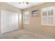 Neutral bedroom with carpet floors, bright windows with blinds, and closet with sliding doors at 21026 N Circle Cliffs Dr, Surprise, AZ 85387