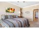 Bright bedroom featuring neutral walls, carpeted floors, and a comfortable bed with colorful bedding at 21026 N Circle Cliffs Dr, Surprise, AZ 85387