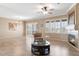 Open-concept living room featuring fireplace, ceiling fan, and view of tile flooring and plantation shutters at 21026 N Circle Cliffs Dr, Surprise, AZ 85387