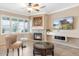 Cozy living room featuring a corner fireplace, tile flooring, and plantation shutters at 21026 N Circle Cliffs Dr, Surprise, AZ 85387