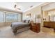 Main bedroom features a bay window, bedside table and attached bath and neutral decor at 21026 N Circle Cliffs Dr, Surprise, AZ 85387