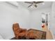 Cozy room featuring a ceiling fan, a leather chair, an ottoman and a view into the main bedroom at 2140 W Mitchell Dr, Phoenix, AZ 85015