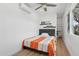 Cozy bedroom features a ceiling fan, window, mini-split AC, floating shelves, and built in shelving unit at 2140 W Mitchell Dr, Phoenix, AZ 85015