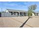 Single story home with covered porch, desert landscaping, decorative shutters, and gray exterior at 2140 W Mitchell Dr, Phoenix, AZ 85015