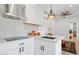 Modern kitchen with white cabinetry, stainless steel appliances, gold fixtures, and stylish backsplash for a contemporary look at 2140 W Mitchell Dr, Phoenix, AZ 85015