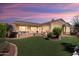 Spacious backyard featuring a covered patio, lush lawn, and mature landscaping at 23108 N Pedregosa Dr, Sun City West, AZ 85375
