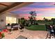 Inviting covered patio with comfortable seating, a fire pit, and picturesque golf course views at 23108 N Pedregosa Dr, Sun City West, AZ 85375