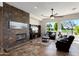 Cozy living room with a stone fireplace, comfortable seating, and views of the golf course at 23108 N Pedregosa Dr, Sun City West, AZ 85375