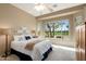 Inviting main bedroom with carpet, ceiling fan, and a scenic window overlooking the golf course at 23108 N Pedregosa Dr, Sun City West, AZ 85375