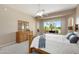 Bright main bedroom with large windows offering golf course views, ceiling fan, and wood furnishings at 23108 N Pedregosa Dr, Sun City West, AZ 85375