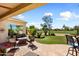 Covered outdoor patio with comfortable seating area overlooking the lush green lawn and golf course at 23108 N Pedregosa Dr, Sun City West, AZ 85375