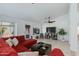 Bright living room with tile floors, white walls, ceiling fan, and backyard access at 3544 E Tonto Ln, Phoenix, AZ 85050