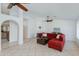 Open-concept living room with white walls, arched doorways, tile floors, and bright natural light at 3544 E Tonto Ln, Phoenix, AZ 85050
