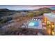 Elevated view showcasing the sparkling pool and lounge chairs alongside desert vegetation and mountain vistas at 36190 N Creek View Ln, Cave Creek, AZ 85331