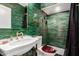 Stylish bathroom featuring emerald subway tiles, gold fixtures, and elegant sink at 374 E Verde Ln, Phoenix, AZ 85012
