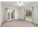 Cozy bedroom with neutral carpeting, large windows, and access to an outdoor patio at 374 E Verde Ln, Phoenix, AZ 85012
