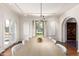 Dining room with long wooden table, white chairs, and hanging light fixture at 374 E Verde Ln, Phoenix, AZ 85012