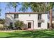 Charming two-story home with red tile roof, stucco walls, and manicured lawn featuring palm trees at 374 E Verde Ln, Phoenix, AZ 85012
