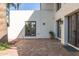 A backyard brick patio features dark trimmed windows and doors, plus established landscaping at 374 E Verde Ln, Phoenix, AZ 85012